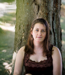 Photo of a white woman in a dark shirt in front of a tree