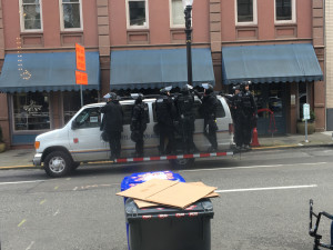 Portland riot cops Several Portland cops hanging off the side of a van in daylight