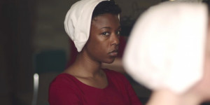 Samira Wiley as Moira Samira Wiley in Handmaid Costume: red dress, white hair covering