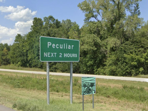 An image of a sign on a Missouri highway that says "Peculiar Two Exits" except the word "exits" has been changed to "hours" & the Self Help Radio logo is on the picture.