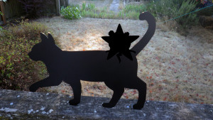 A silhouette of a cat with a silhouette of the Self Help Radio logo added to it.