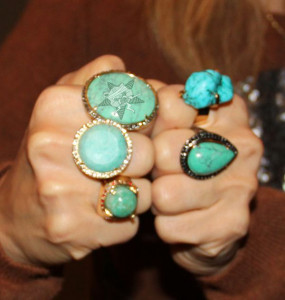 A giant turquoise ring with the Self Help Radio logo on it.