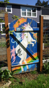 A picture of a fire-breathing unicorn painted on a fence.