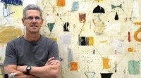 Photo of Nick Wilton in front of one of his paintings